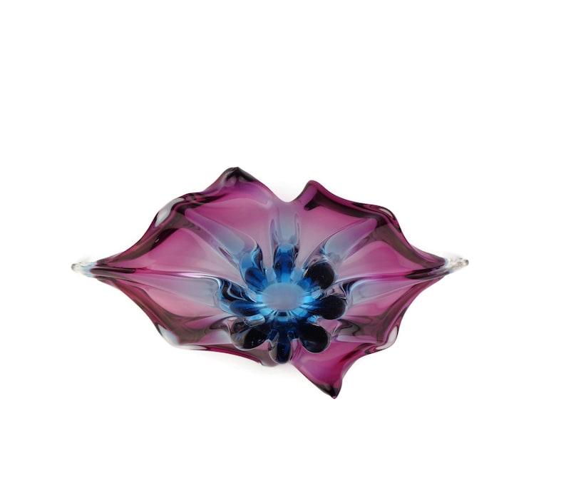 Peut inclure: Un bol en verre violet et bleu avec un motif floral. Le bol est en verre souffl&eacute; et a une forme unique et organique.