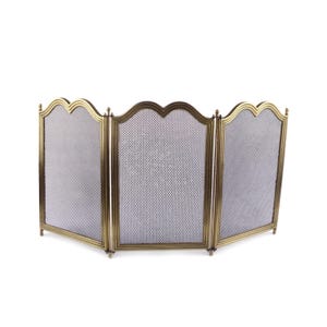 May include: A three-panel fireplace screen with a brass-coloured frame and a fine mesh screen. The frame has a decorative, scalloped top edge. The screen is designed to stand on its own and protect the area around a fireplace.