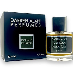 May include: A perfume bottle and box set. The bottle is clear with a dark cap and a label that reads "DARREN ALAN DORIAN'S FOUGÈRE parfum 1.7 fl oz." The box is dark blue with white text that reads "DARREN ALAN PERFUMES" and "DORIAN'S FOUGÈRE" with "50 ml e."