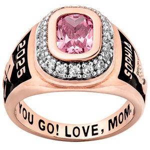 May include: A rose gold class ring with a pink gemstone and a black enamel band. The band is engraved with "2025" and "SOCCER" and the inside of the band is engraved with "YOU GO! LOVE, MOM."