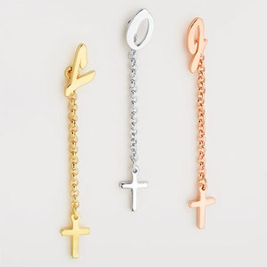 May include: Three gold, silver, and rose gold necklaces with a cross charm at the end. Each necklace features a different letter charm at the top.