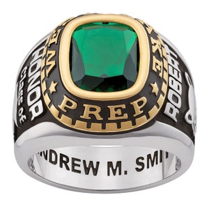 May include: A silver and gold class ring with a green gemstone. The ring says "Robert E. Lee Prep" and "Class of" with a star and a horse head design. The inscription on the band reads "Andrew M. Smith".