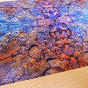 May include: Abstract art print with a blue, purple, and orange color scheme. The print features a swirling, organic pattern that resembles a natural rock formation.