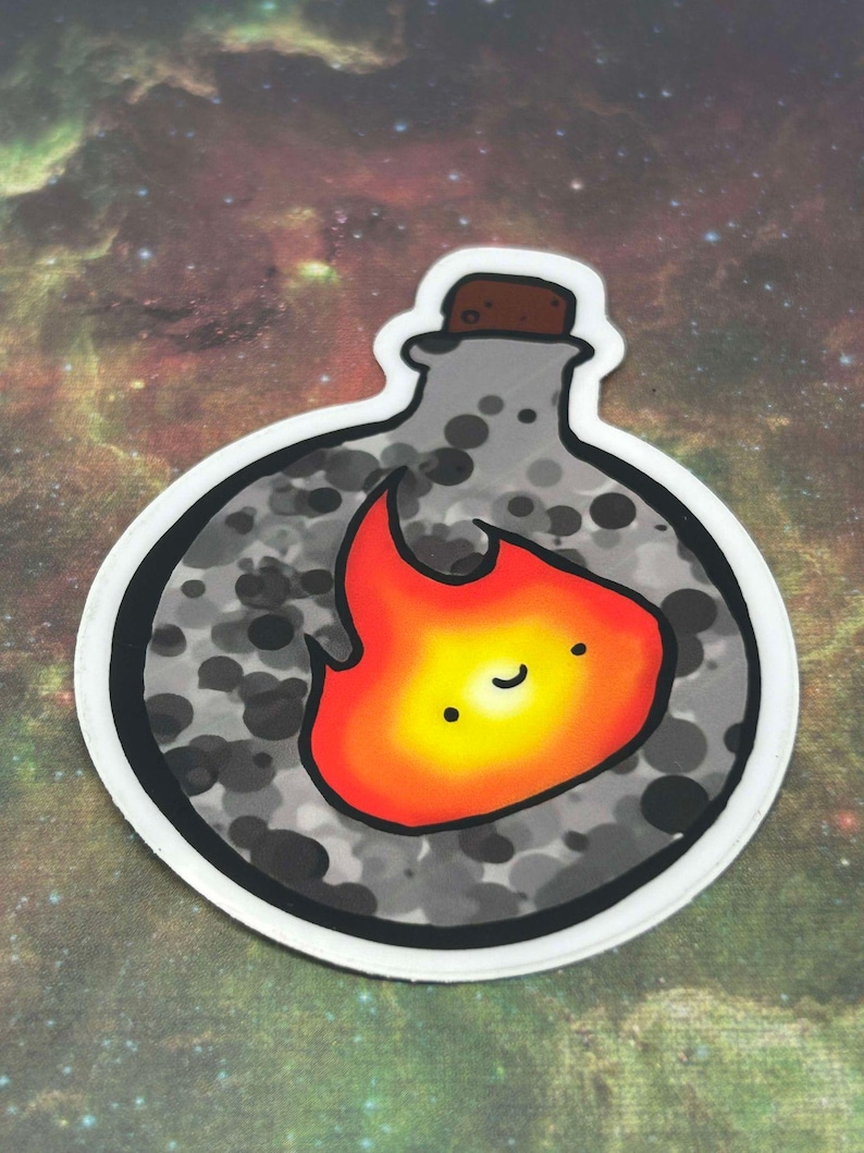 Puede incluir: Una pegatina redonda con una botella gris con un tap&oacute;n de corcho y una llama naranja sonriente en su interior. La botella tiene un patr&oacute;n gris y negro moteado.