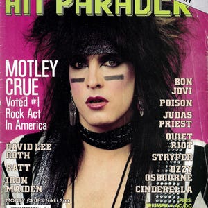 May include: A vintage January 1987 issue of Hit Parader magazine. The cover features Motley Crue, with the text "Voted #1 Rock Act In America." Other bands listed include Bon Jovi, Poison, and Judas Priest. The background is a vibrant pink.