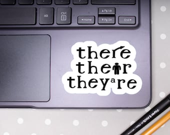 Può includere: Un adesivo bianco con testo nero su un laptop. Il testo dice "there, their, they're".