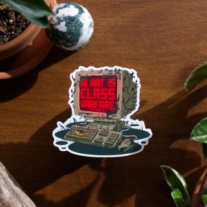 May include: A sticker featuring a retro computer design with the text "AI ART IS CLASS WARFARE" in red on the screen. The computer is surrounded by a green, decaying aesthetic, suggesting a dystopian theme.