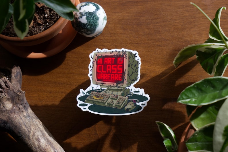May include: A sticker featuring a retro computer design with the text "AI ART IS CLASS WARFARE" in red on the screen. The computer is surrounded by a green, decaying aesthetic, suggesting a dystopian theme.
