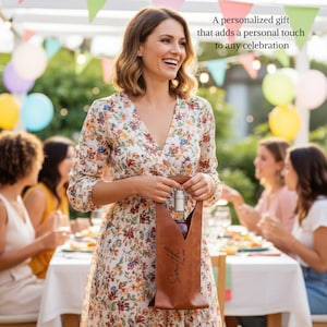 Woman at an outdoor party holding a personalized leather wine tote bag with engraved text, a unique gift idea for birthdays, weddings, anniversaries, and celebrations
