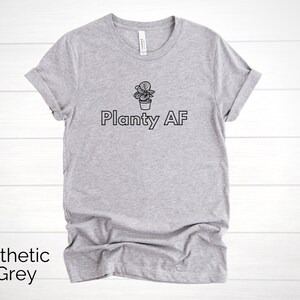 May include: A heather grey t-shirt with a black outline of a potted plant and the text "Planty AF".