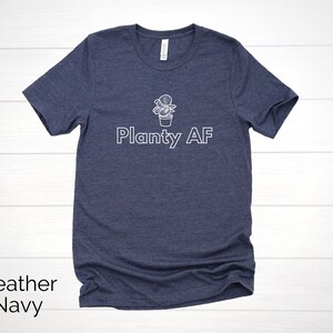 May include: A heather navy blue t-shirt with a white graphic of a potted plant and the text "Planty AF".