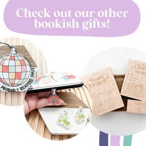 K&ouml;nnte beinhalten: Bild mit verschiedenen buchigen Geschenken. Enth&auml;lt einen Disco-Kugel-Ornament mit Text, einen Regenbogen-Anh&auml;nger und Holzstempel f&uuml;r Buchbesprechungen und -verfolgung. Der Text "Check out our other bookish gifts!" ist ebenfalls sichtbar.