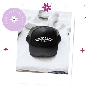 Peut inclure: Casquette de camionneur noire en mesh avec du texte blanc qui dit "BOOK CLUB babe".