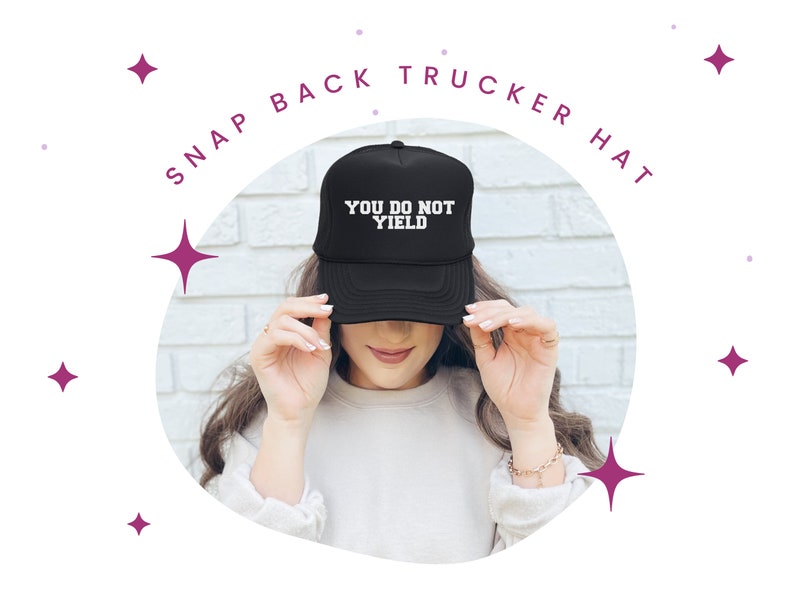 K&ouml;nnte beinhalten: Schwarze Snapback-Trucker-M&uuml;tze mit dem wei&szlig;en Text "YOU DO NOT YIELD". Die M&uuml;tze wird von einer Person getragen. Das Bild ist vor einem wei&szlig;en Hintergrund mit dekorativen Sternformen platziert.