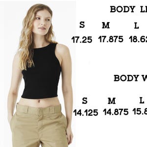 May include: Two women wearing crop tops, one white and one black. The image includes a size chart with body length and width measurements in inches for sizes S to XXL. 1 inch is 2.54 cm.