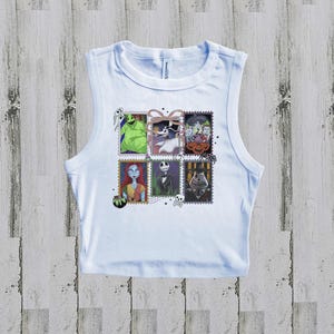 May include: White vest top with a colourful graphic of postage stamps featuring characters from The Nightmare Before Christmas. The stamps include images of Jack Skellington, Sally, and Oogie Boogie.
