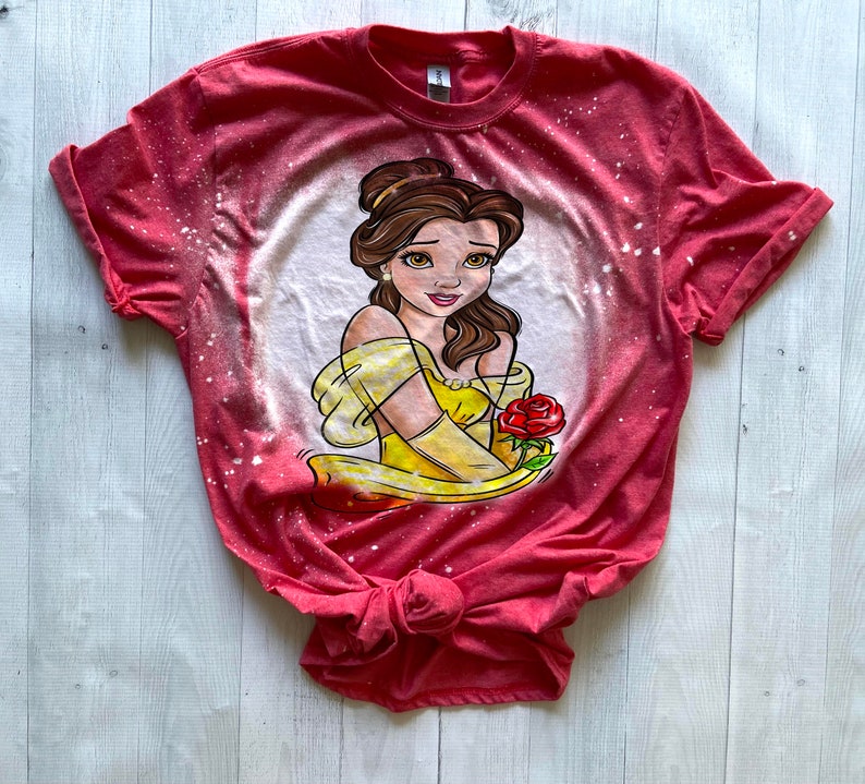 May include: Red t-shirt with a bleach-splattered design featuring a cartoon image of Belle from Beauty and the Beast holding a red rose.
