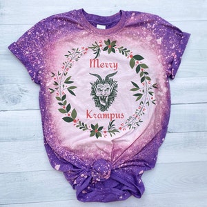 May include: Purple tie-dye t-shirt with a pink and green wreath design featuring a cartoon Krampus with the text "Merry Krampus".
