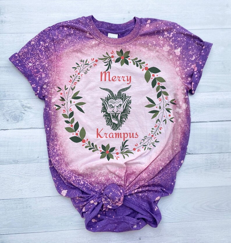 May include: Purple tie-dye t-shirt with a pink and green wreath design featuring a cartoon Krampus with the text "Merry Krampus".