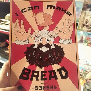 Peut inclure: Une affiche rouge, blanche et marron avec un personnage de dessin animé avec une barbe et des cornes. Le personnage tient une miche de pain. L'affiche dit "Je peux faire du pain. Senishi."