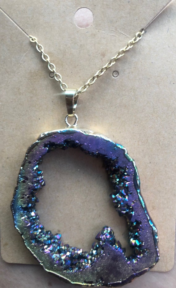 Beautiful rainbow titanium aura quartz pendant that is surrounded by gold and hung on a gold chain custom to you size preference; geode