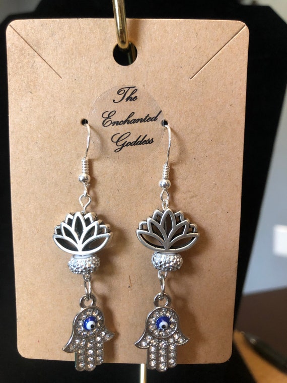 beautiful lotus flower(Kamala in sanskrit) and crystals encasing a  protective blue evil eye on a Hasma hand or hand of fatima, personalized