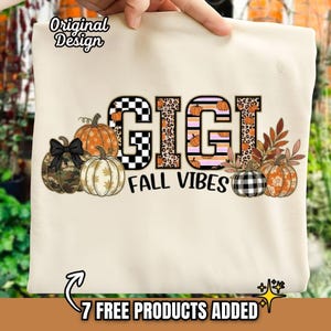 Op de afbeelding: Crèmekleurige draagtas met de tekst "GIGI FALL VIBES". Het woord "GIGI" is versierd met een dambordpatroon, luipaardprint en pompoenen. Het ontwerp bevat pompoenen en herfstbladeren.