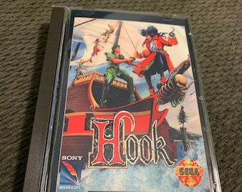 May include: A Sega CD game case featuring a colourful illustration of Captain Hook and Peter Pan on a pirate ship. The game title "Hook" is displayed in large, red letters. The case is labelled "Sega CD" and "Imagesoft".