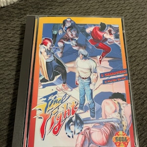 May include: A Sega CD game case with a red, white, and blue background. The game is called "Final Fight CD" and features a group of characters fighting. The text "3 Characters! 2 Player Co-Op!" is printed on the case. The Sega logo is in the bottom right corner.