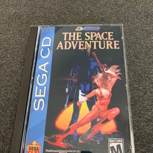 Pode incluir: Uma caixa de jogo Sega CD para "The Space Adventure" com classificação para adultos. A capa apresenta uma mulher com um macacão vermelho e um homem com um macacão azul segurando armas. O jogo é baseado na série de anime japonesa "Goera" de Buichi Terasawa.