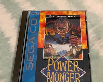 May include: A Sega CD game case for Power Monger by Bullfrog Productions. The case is blue and white with a picture of a man with a sword on the front. The game is rated MA-13 by the V.R.C.