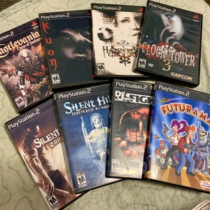 May include: A collection of nine PlayStation 2 video game cases. The cases are arranged in a semi-circle, with the titles facing the viewer. The titles include Castlevania: Curse of Darkness, Kuon, Silent Hill: Shattered Memories, Silent Hill Origins,  Haunting Ground, Clock Tower 3,  Def Jam Fight for NY, and Futurama.