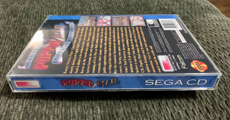 May include: A SEGA CD game case for "Popful Mail: Magic Fantasy Adventure." The case is clear plastic with a blue border and features colorful graphics and text. The game's title is prominently displayed.