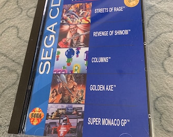 May include: A blue Sega CD game case featuring a red racing car on the front. The title "SEGA CLASSICS ARCADE COLLECTION" is printed in white at the top of the case. The game titles "STREETS OF RAGE", "REVENGE OF SHINOBI", "COLUMNS", "GOLDEN AXE", and "SUPER MONACO GP" are printed in white on the case.
