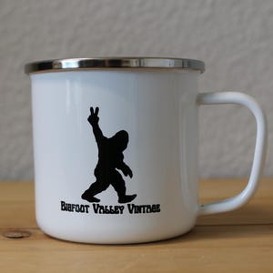 Taza de camping de metal esmaltado vintage de Bigfoot Valley. Compre artículos para seguidores y fanáticos del Sasquatch. Taza de 12 oz para café o té. Símbolo de la paz de Bigfoot.