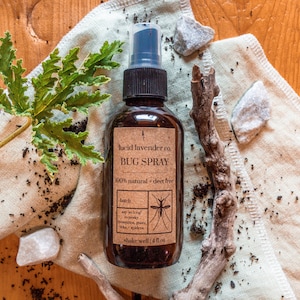 May include: A brown glass bottle with a black spray nozzle and a label that reads "lucid lavender co. BUG SPRAY 100% natural deet free batch say so konf lepesky kapédere shake well 4 fl oz".