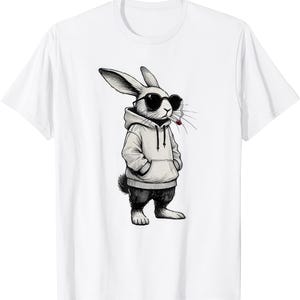 Puede incluir: Camiseta blanca con una ilustración en blanco y negro de un conejo con gafas de sol y una sudadera con capucha, con un cigarrillo en la boca. El conejo está de pie con las manos en los bolsillos.
