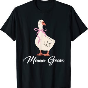 May include: Black t-shirt featuring a cartoon goose with a pink bow and orange feet. The goose has a white body and a brown beak. The words "Mama Goose" are written in white script below the goose.