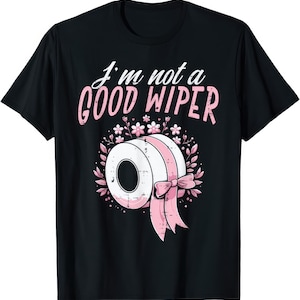 May include: Black t-shirt with the text "I'm not a GOOD WIPER" in white and pink. The graphic features a roll of toilet paper with a pink ribbon and floral accents. A humorous and playful design.