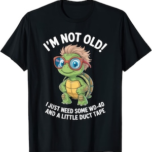 Puede incluir: Camiseta negra con una tortuga de dibujos animados con gafas y una frase divertida. El texto dice: "I'M NOT OLD! I JUST NEED SOME WD-40 AND A LITTLE DUCT TAPE."