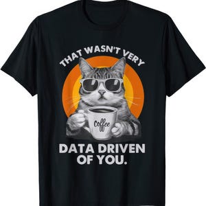 Könnte beinhalten: Schwarzes T-Shirt mit einer Comic-Katze, die eine Sonnenbrille trägt und eine Kaffeetasse hält. Der Text "That wasn't very data driven of you." ist auf das T-Shirt gedruckt.
