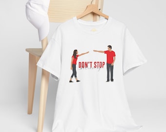 Op de afbeelding: Wit T-shirt met een rode afbeelding van twee mensen die naar elkaar reiken. De tekst "DON'T STOP believing" is onder de afbeelding gedrukt.