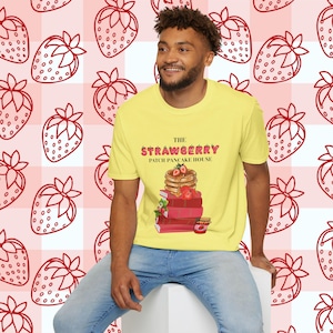 May include: A yellow t-shirt with the text "The Strawberry Patch Pancake House" and a graphic of a stack of pancakes with strawberries on top.