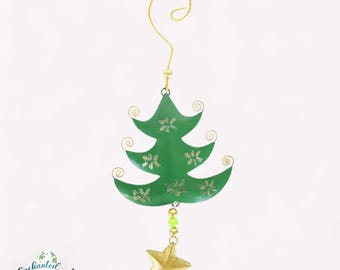 May include: A green metal Christmas tree ornament with a gold star at the bottom. The tree has snowflake cutouts and gold swirls. A gold hook is at the top for hanging. The ornament is approximately 5 inches tall.