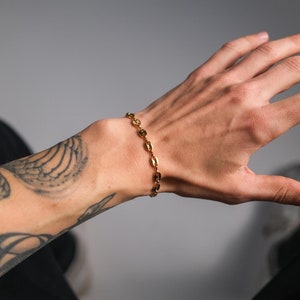 Op de afbeelding: Een gouden kettingarmband met ovale schakels.