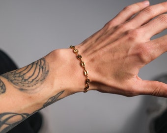 May include: A gold chain bracelet with oval links.