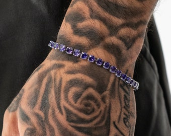 May include: A silver tennis chain bracelet with purple round stones.