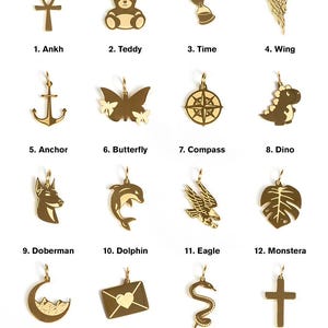 May include: A set of 16 gold-tone charms featuring various designs, including an ankh, teddy bear, hourglass, wing, anchor, butterfly, compass, dinosaur, doberman, dolphin, eagle, monstera leaf, crescent moon, love letter, snake, and cross.