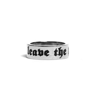 Könnte beinhalten: Silberring mit der Gravur "leave the past" in schwarzen Buchstaben.