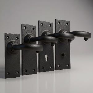May include: Four black door handles with rectangular backplates featuring a textured finish. Each handle has a curved lever and a scalloped top edge. The plates include mounting holes, with one featuring a keyhole and another a privacy turn button.